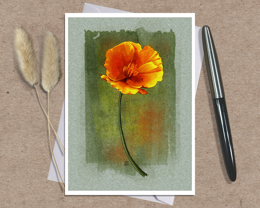 An art print greeting card featuring a watercolor-style orange and yellow flower on a textured green background, styled on a kraft paper surface with a black pen and dried grass stems.