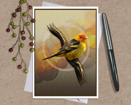 A square art print featuring a yellow and orange bird perched on a branch, styled on a kraft paper background with a white envelope, a silver pen, and decorative berries.