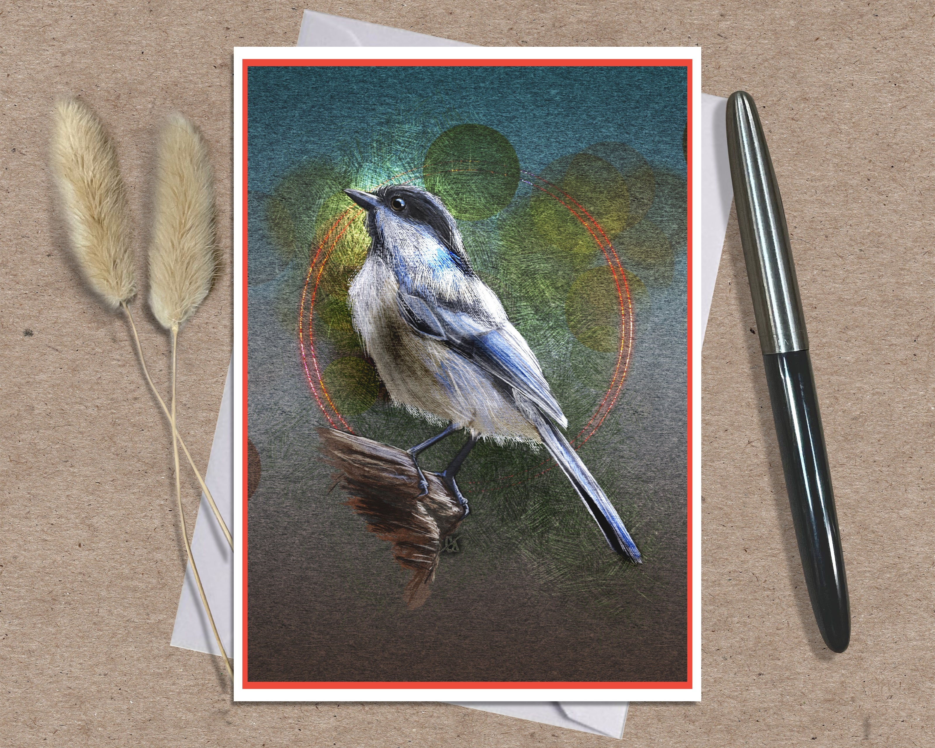 A square art print featuring a detailed bluebird perched on a branch, displayed on a kraft paper background with a black pen and dried bunny tail grass as props.