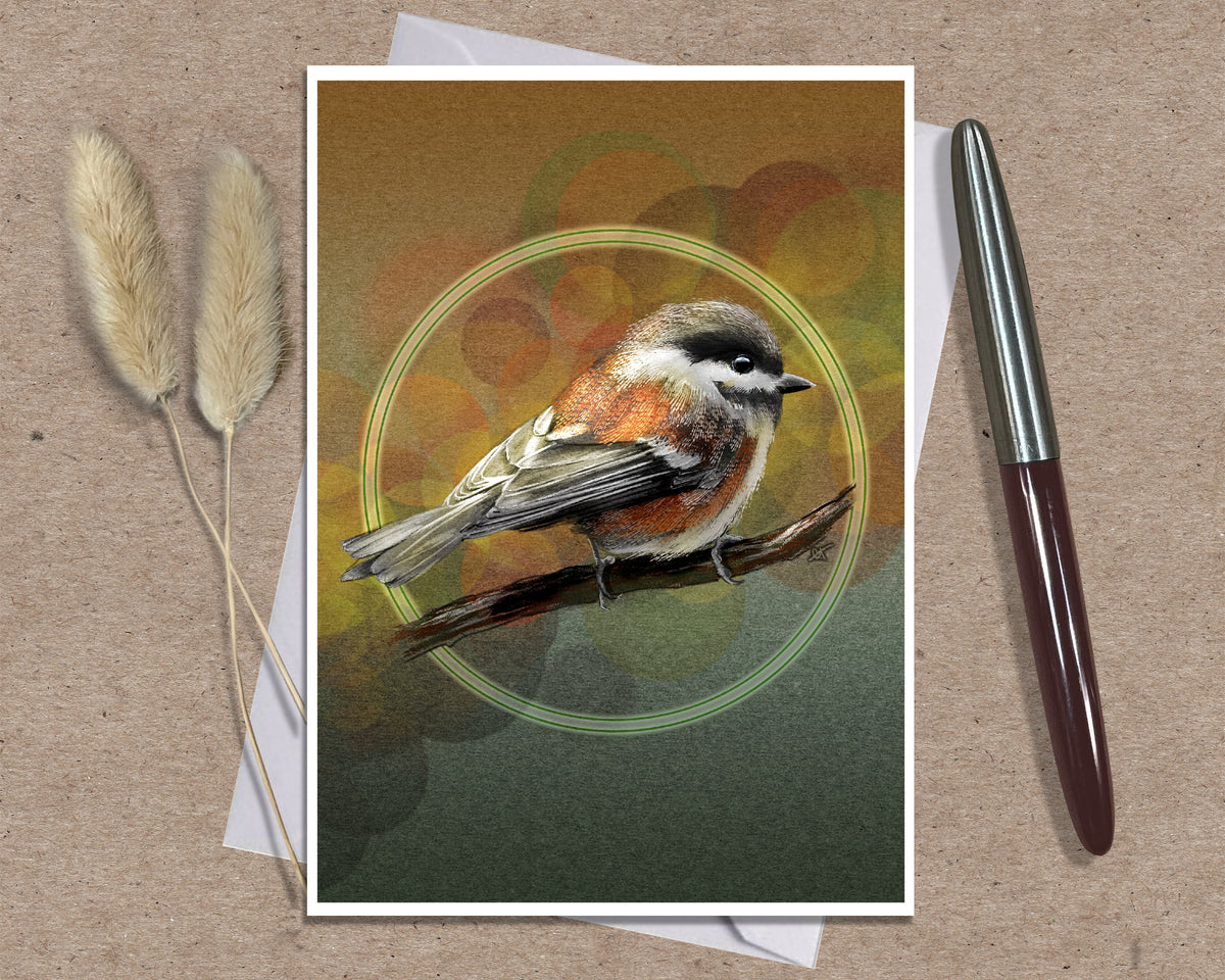 An art print greeting card featuring a detailed bird illustration perched on a branch, displayed on a kraft paper background with two dried grass stems on the left and a silver pen on the right.