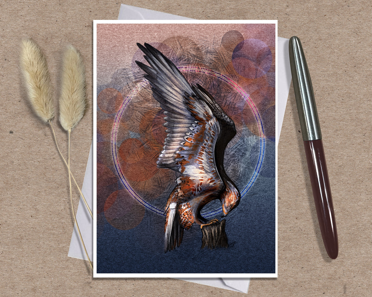 An art print greeting card featuring a detailed illustration of a bird of prey with wings spread, set against an abstract textured background in blue, brown, and orange tones. The print is displayed on a kraft paper background alongside two dried grass stems and a silver and brown pen.