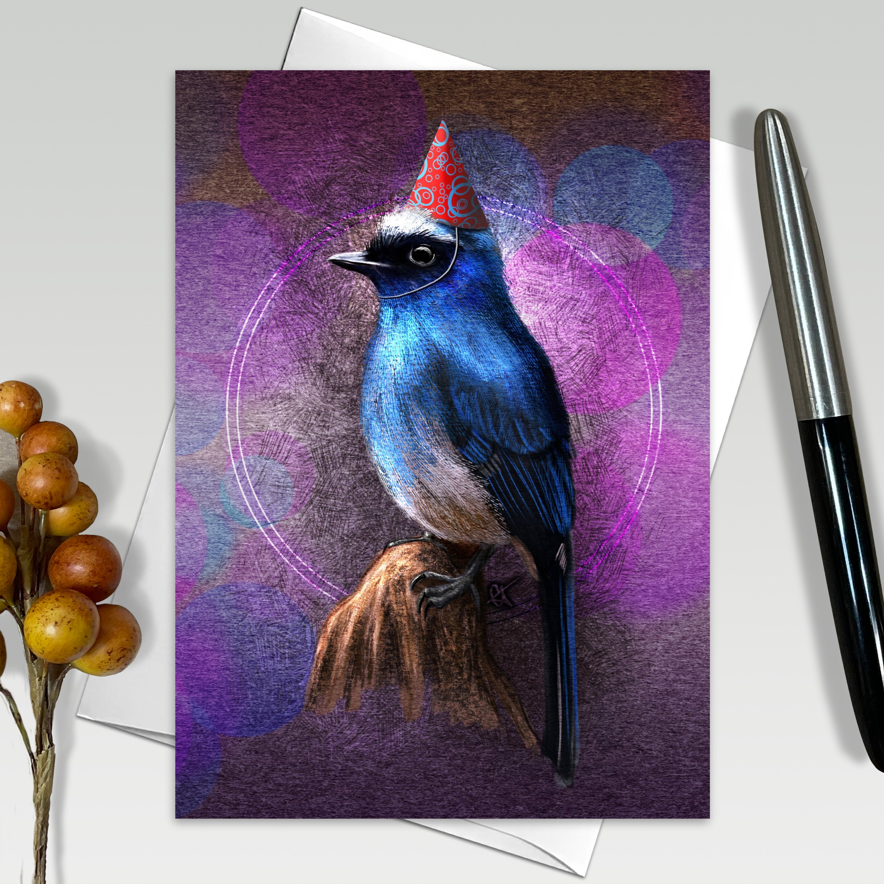 Greeting card with a blue bird wearing a party hat on a purple background, next to a pen and decorative elements.