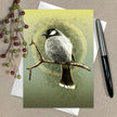 Greeting card with a bird illustration on a branch, surrounded by berries and a pen.