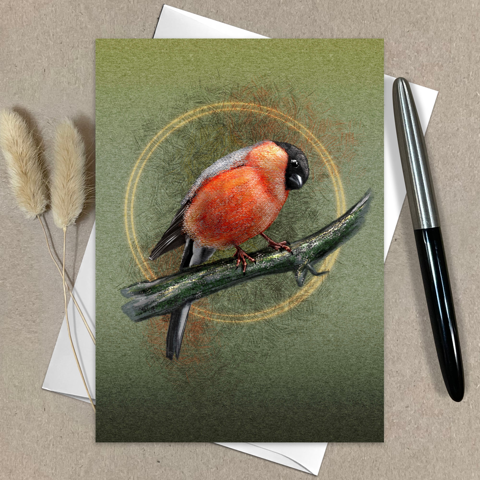 Greeting card with a bird illustration on a green background, accompanied by a pen and dried plants.