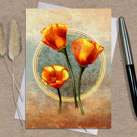 Greeting card with orange flowers on a textured surface with a pen and dried plants.