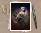 A greeting card featuring a bird perched on a log with a white chef's hat, styled on a kraft paper background with a silver pen and dried grass stems.