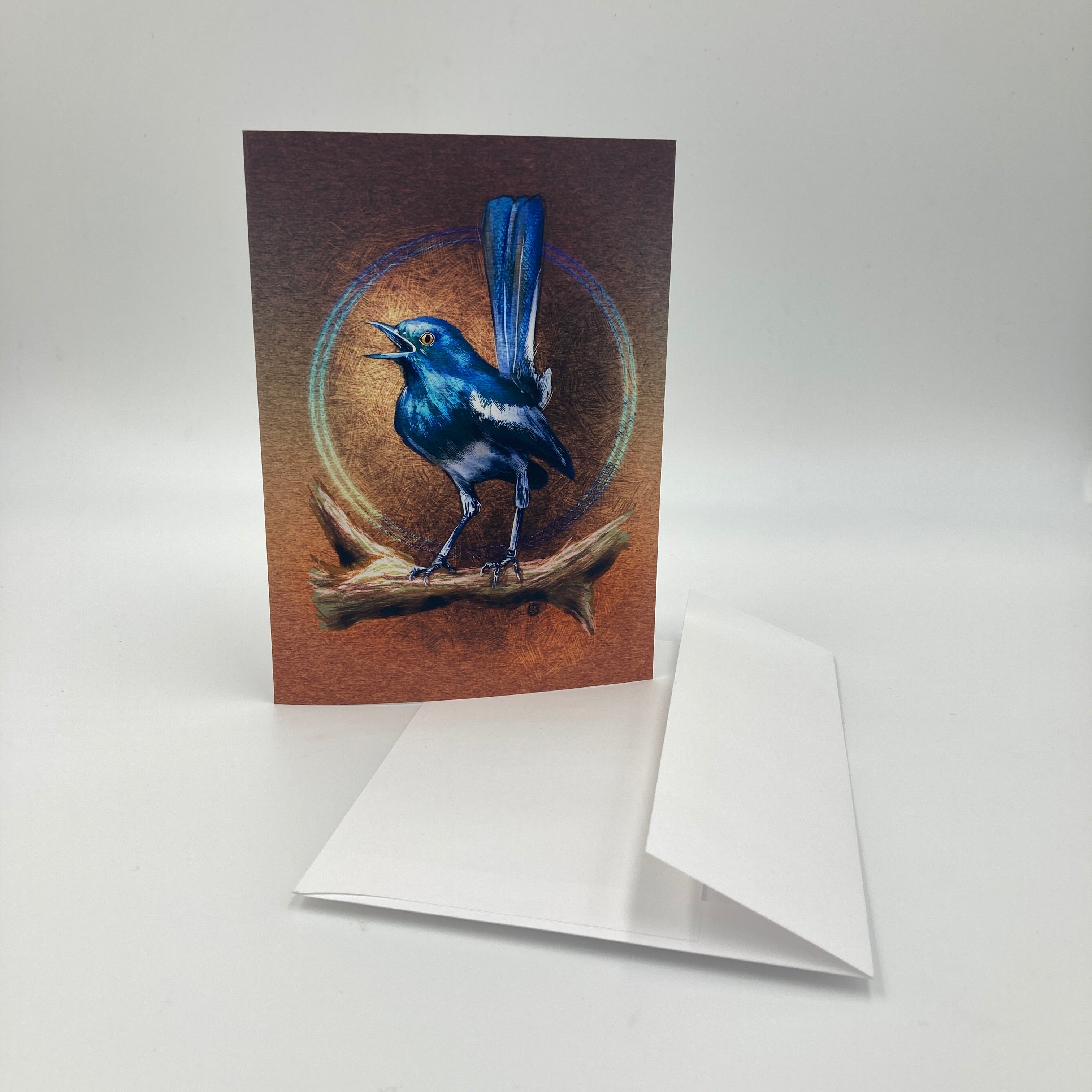 Greeting card with a blue bird illustration on a brown background, featuring a white envelope.