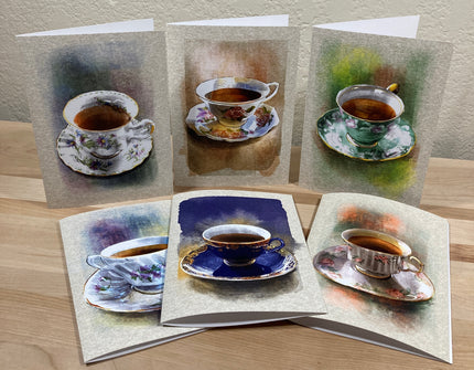 Set of greeting cards with tea cup illustrations on a wooden surface