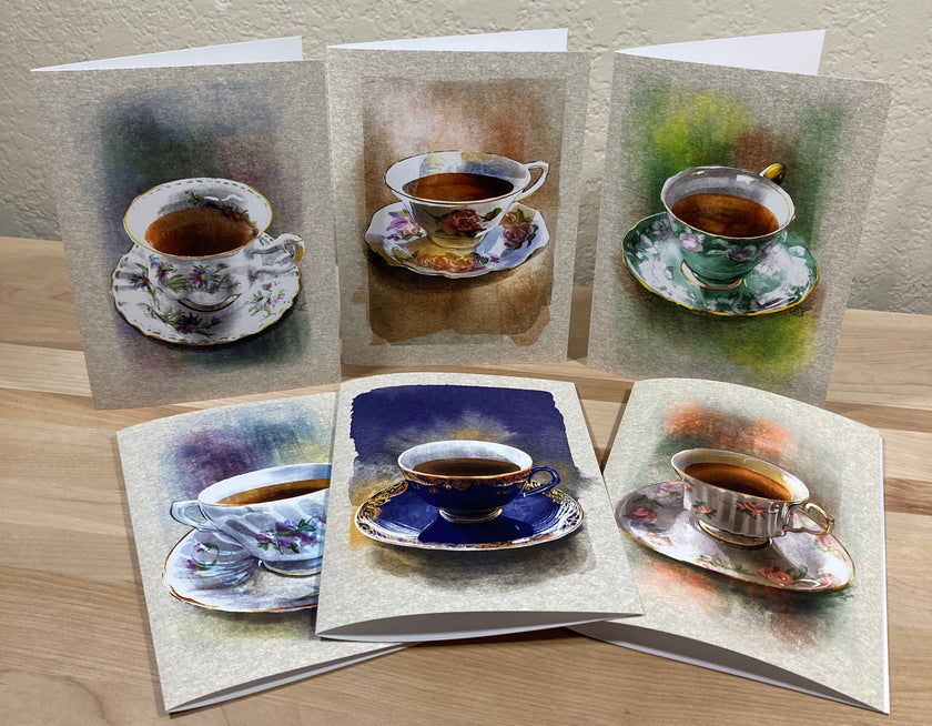 Set of greeting cards with tea cup illustrations on a wooden surface