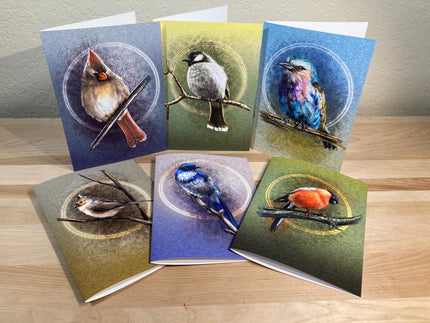 Set of six greeting cards with bird illustrations on a wooden surface.