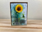 Case of greeting cards with a sunflower design on a wooden surface