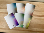 Backside of six colorful greeting cards on a wooden surface