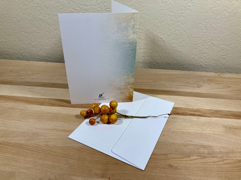 White greeting card with a branch of berries on a wooden surface