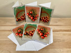 Set of greeting cards with red tomato illustrations on a wooden surface