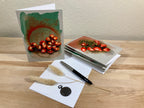 Set of greeting cards with nature-themed designs on a wooden surface.