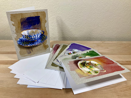 Collection of greeting cards with artistic designs on a wooden surface