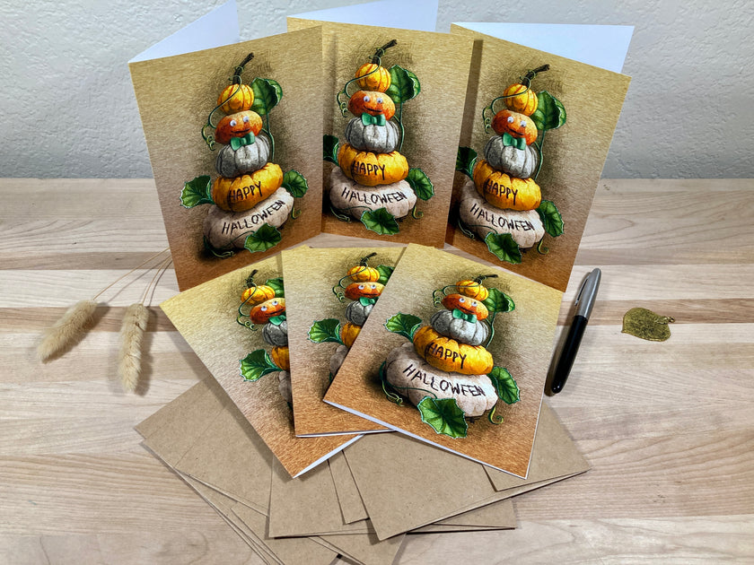 Set of Halloween-themed greeting cards with pumpkins and 'Happy Halloween' text on a wooden surface.