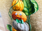 Decorative pillow with pumpkins and leaves on a textured surface
