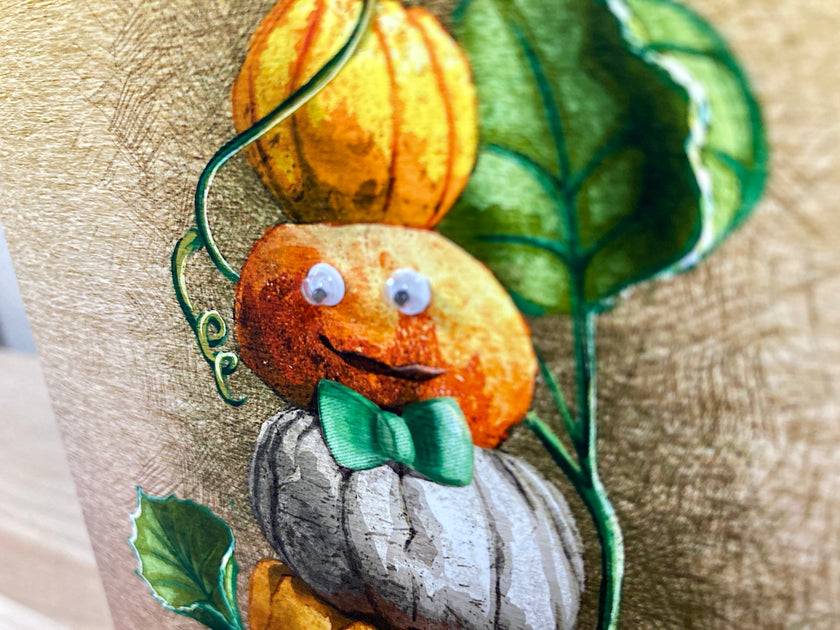 Decorative pillow with pumpkins and leaves on a textured surface