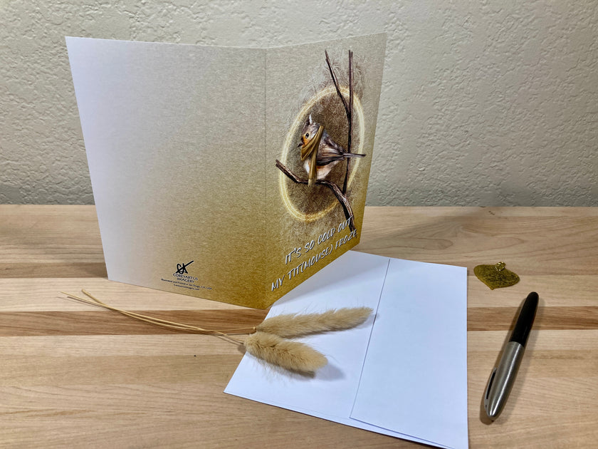Greeting card with nature-themed design on a wooden surface with a pen and decorative elements.