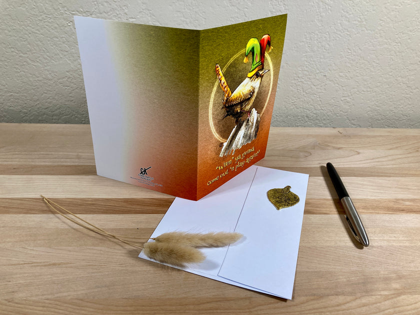 Greeting card with feather on a wooden surface