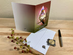 Greeting card with a bird design on a wooden surface with decorative elements.