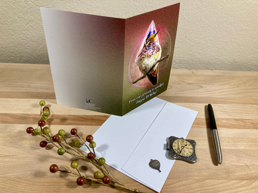 Greeting card with a bird design on a wooden surface with decorative elements.
