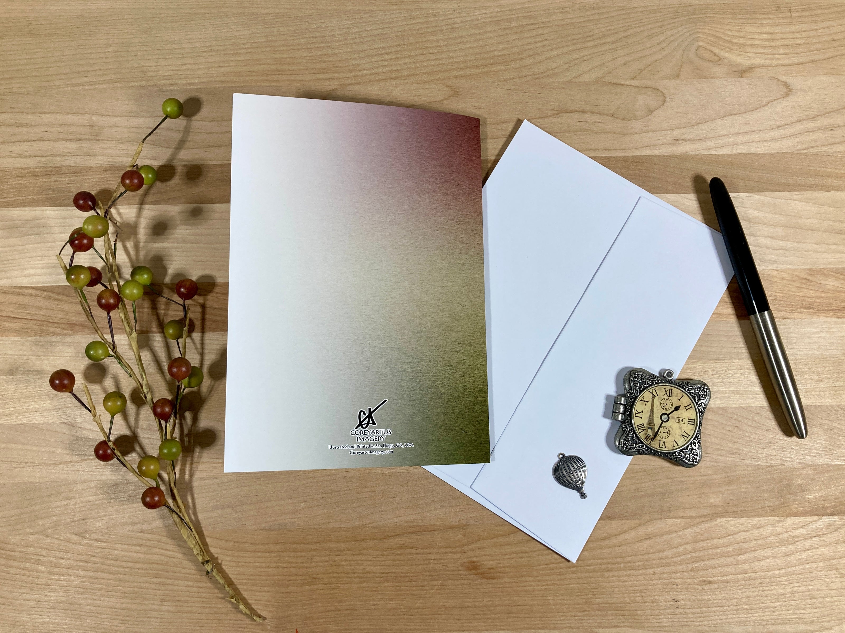Back of a greeting card with a pen,and decorative items on a wooden surface