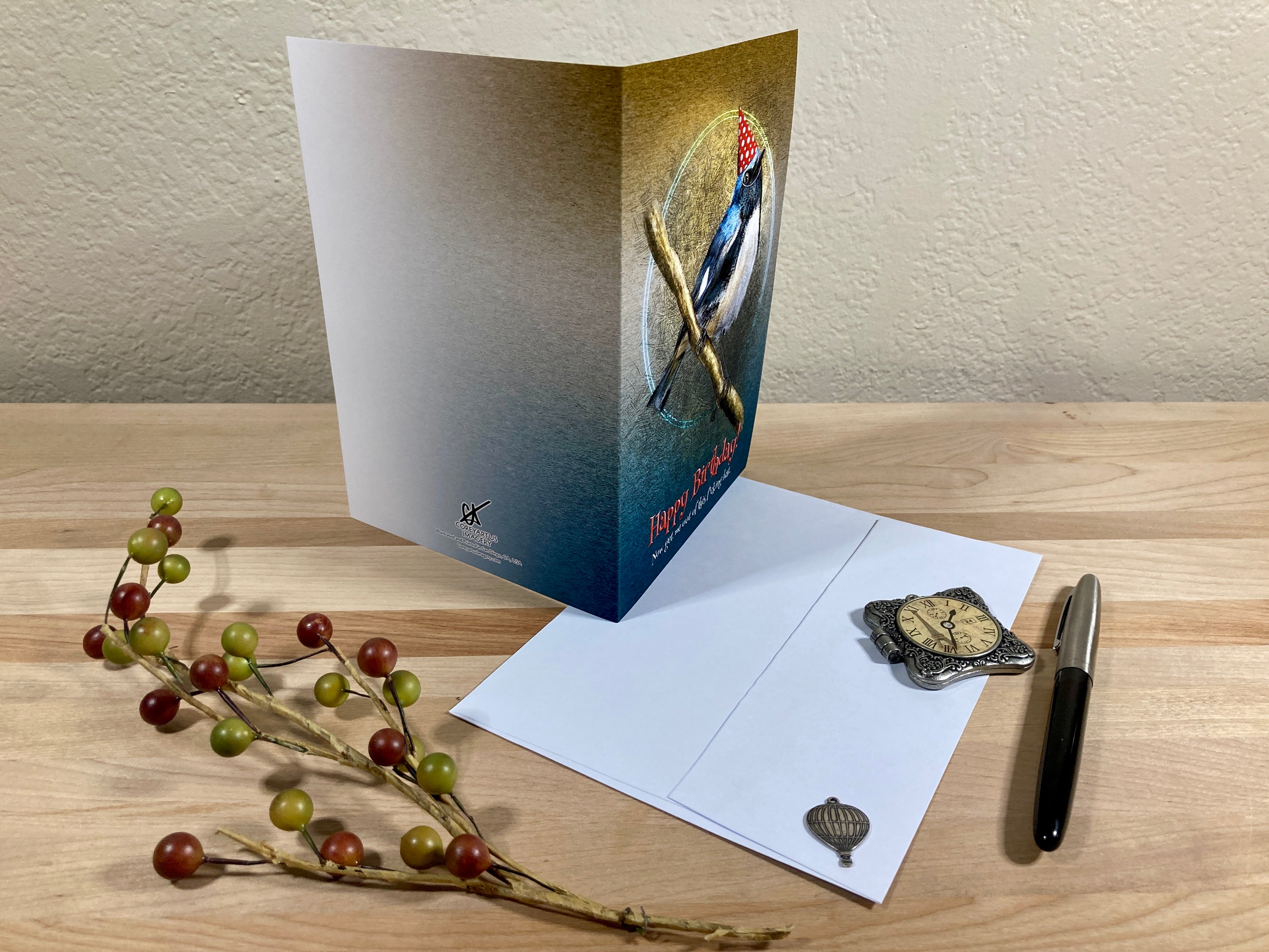 Greeting card with envelope and decorative items on a wooden surface
