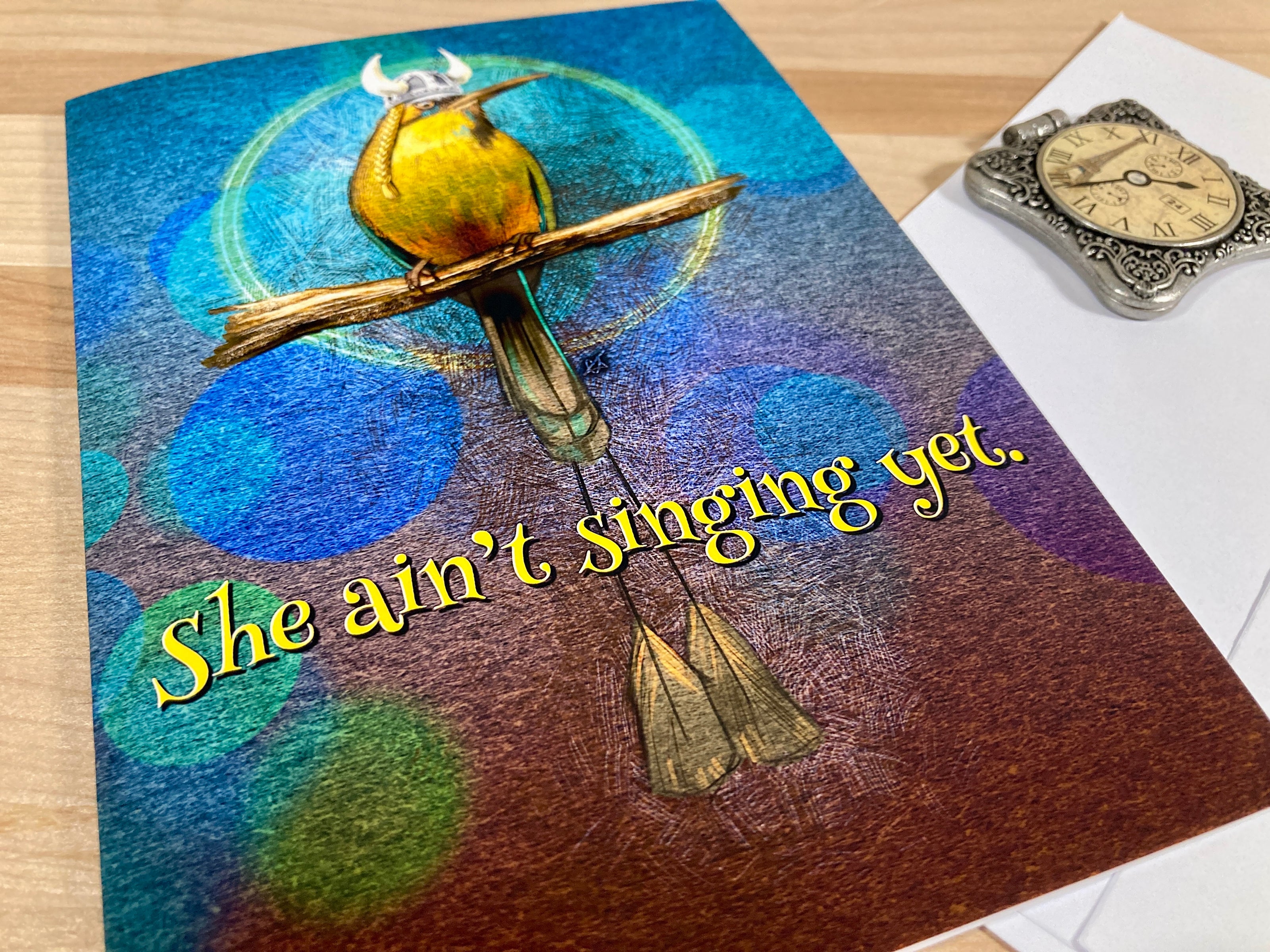 Decorative book with a bird and cross design on a wooden surface