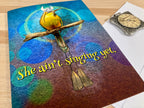 Decorative book with a bird and cross design on a wooden surface
