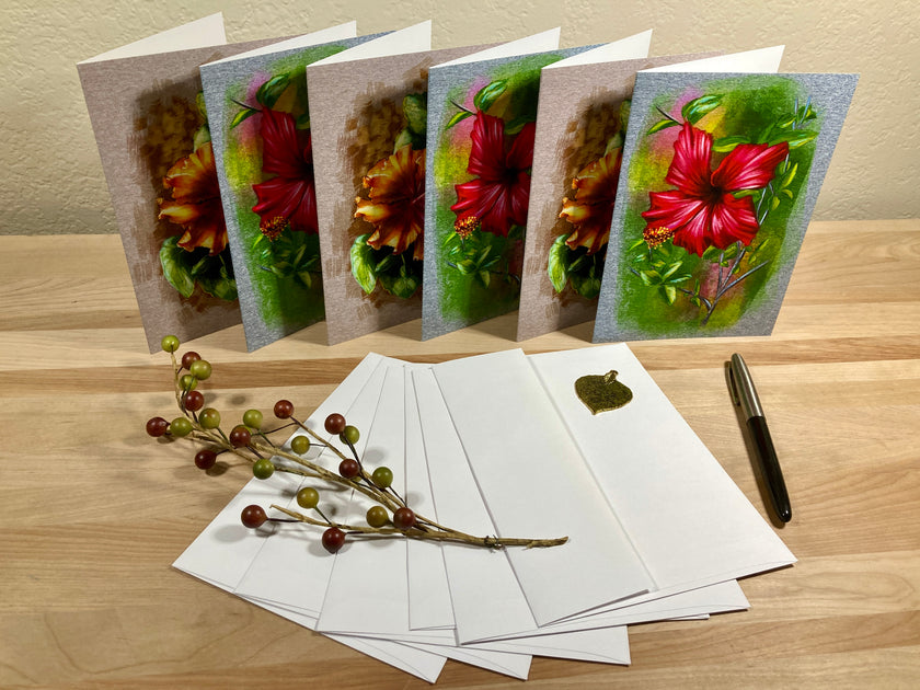 Set of floral greeting cards with envelopes and a pen on a wooden surface