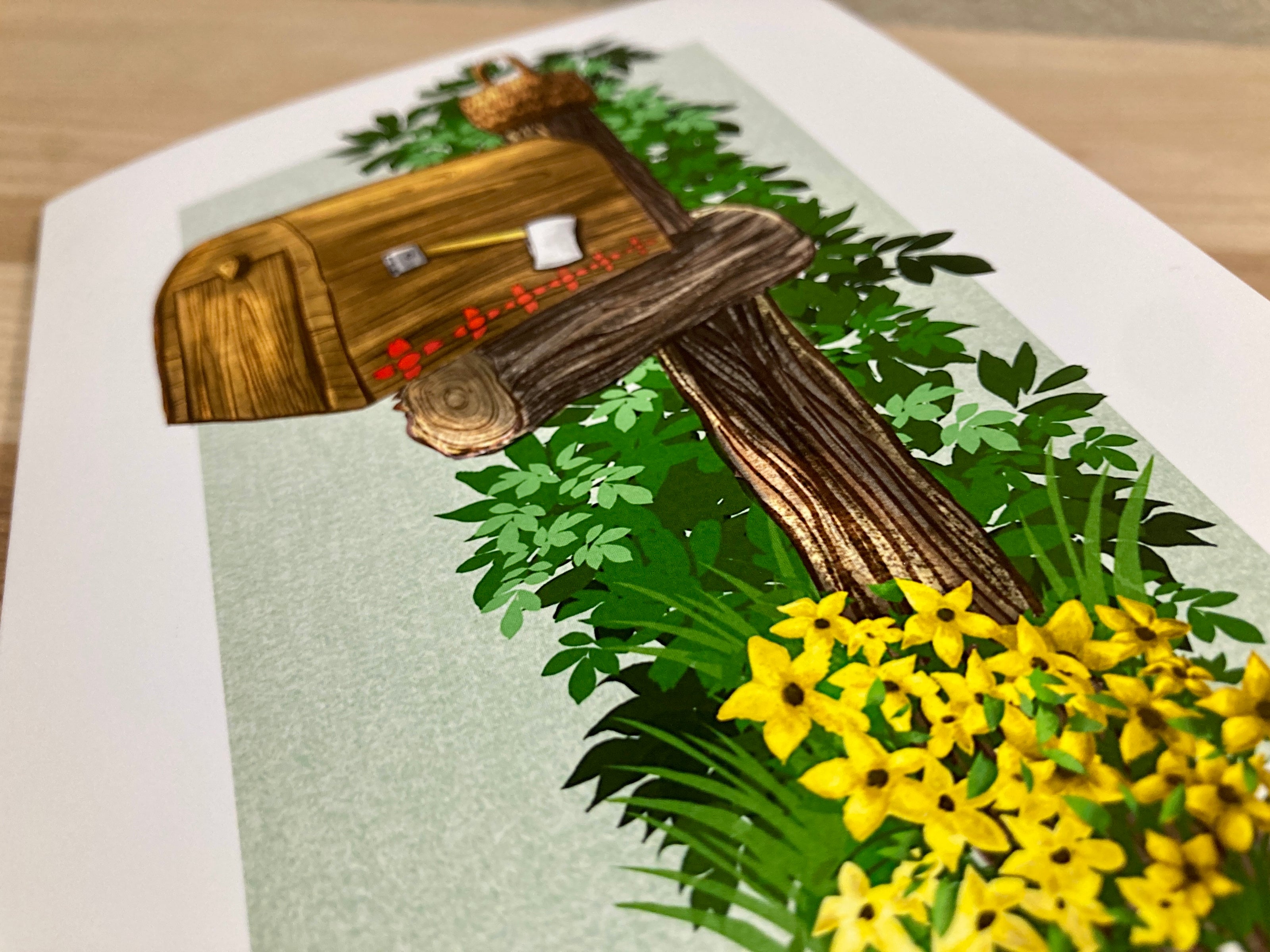 Greeting card featuring a wooden mailbox with leaves and flowers on a card
