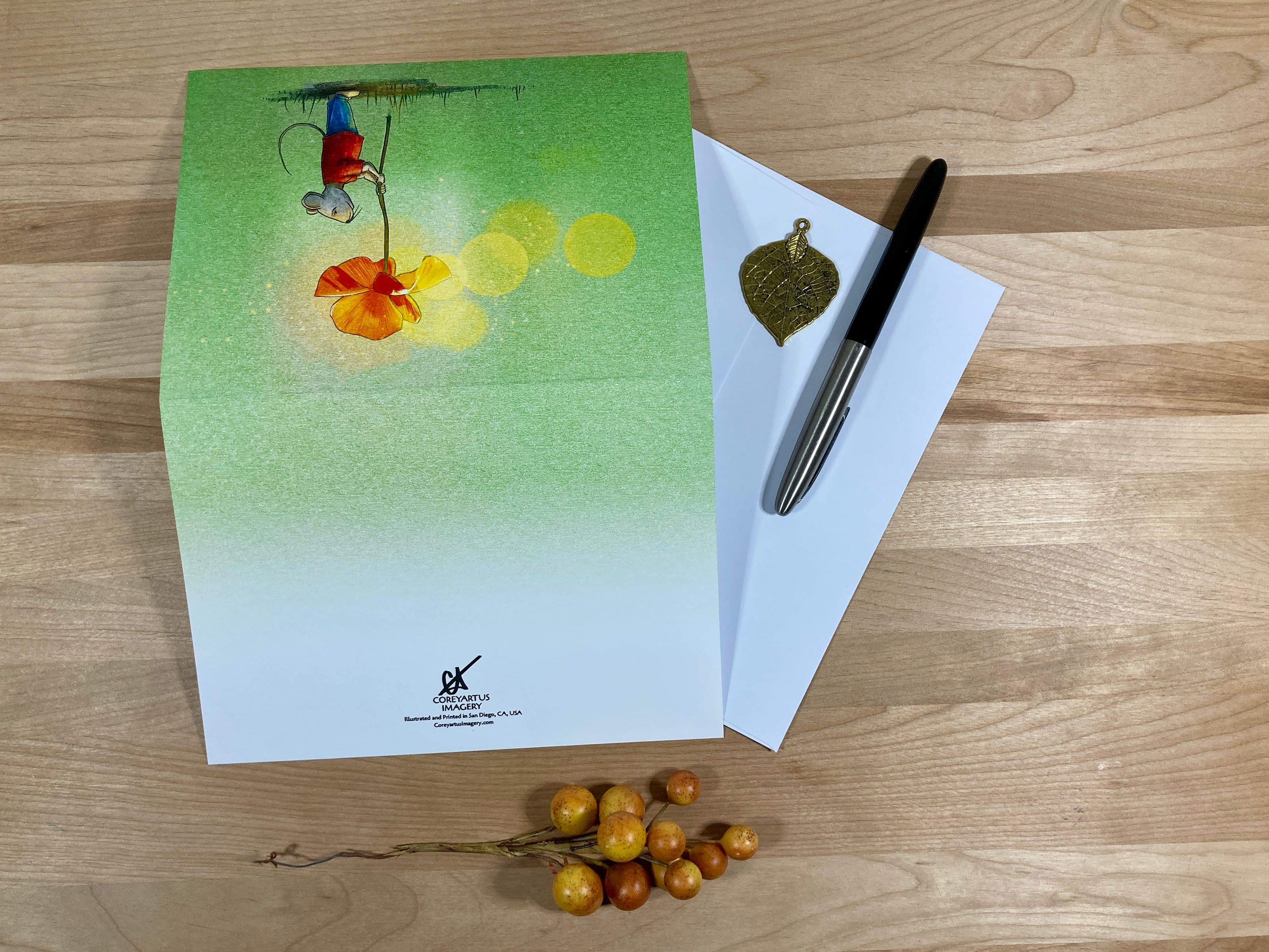 Greeting card with a colorful design, pen, and envelope on a wooden surface