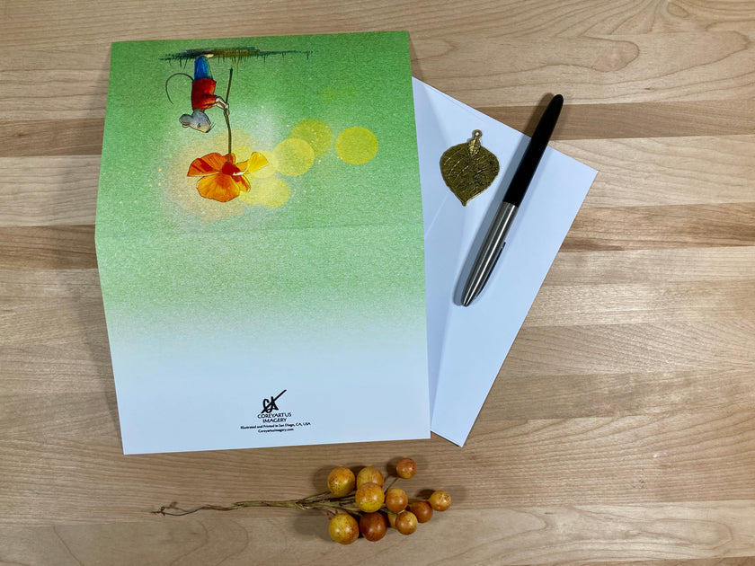 Greeting card with a colorful design, pen, and envelope on a wooden surface