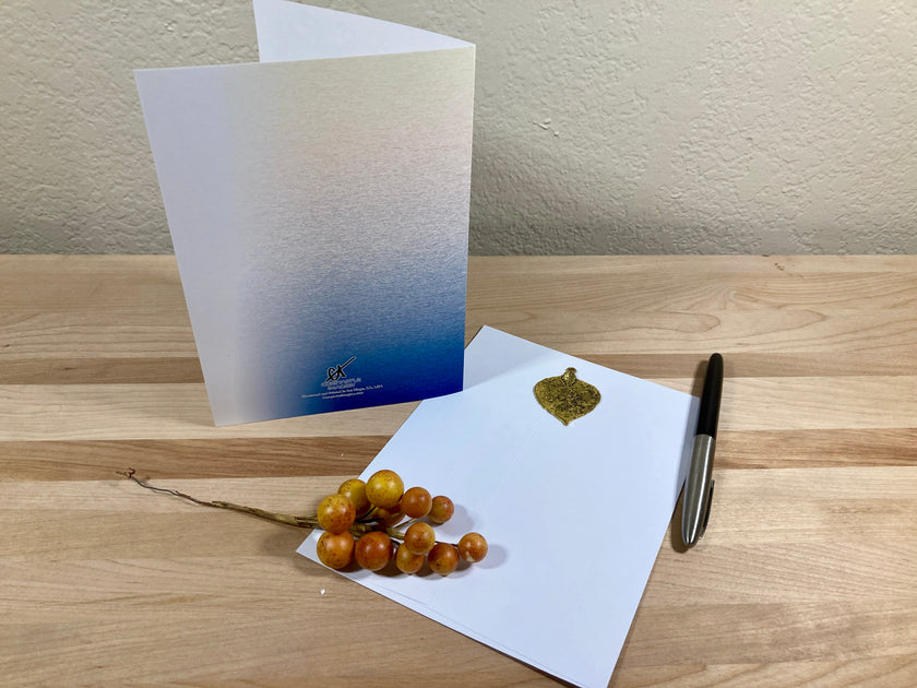 Greeting card with envelope and decorative berries on a wooden surface