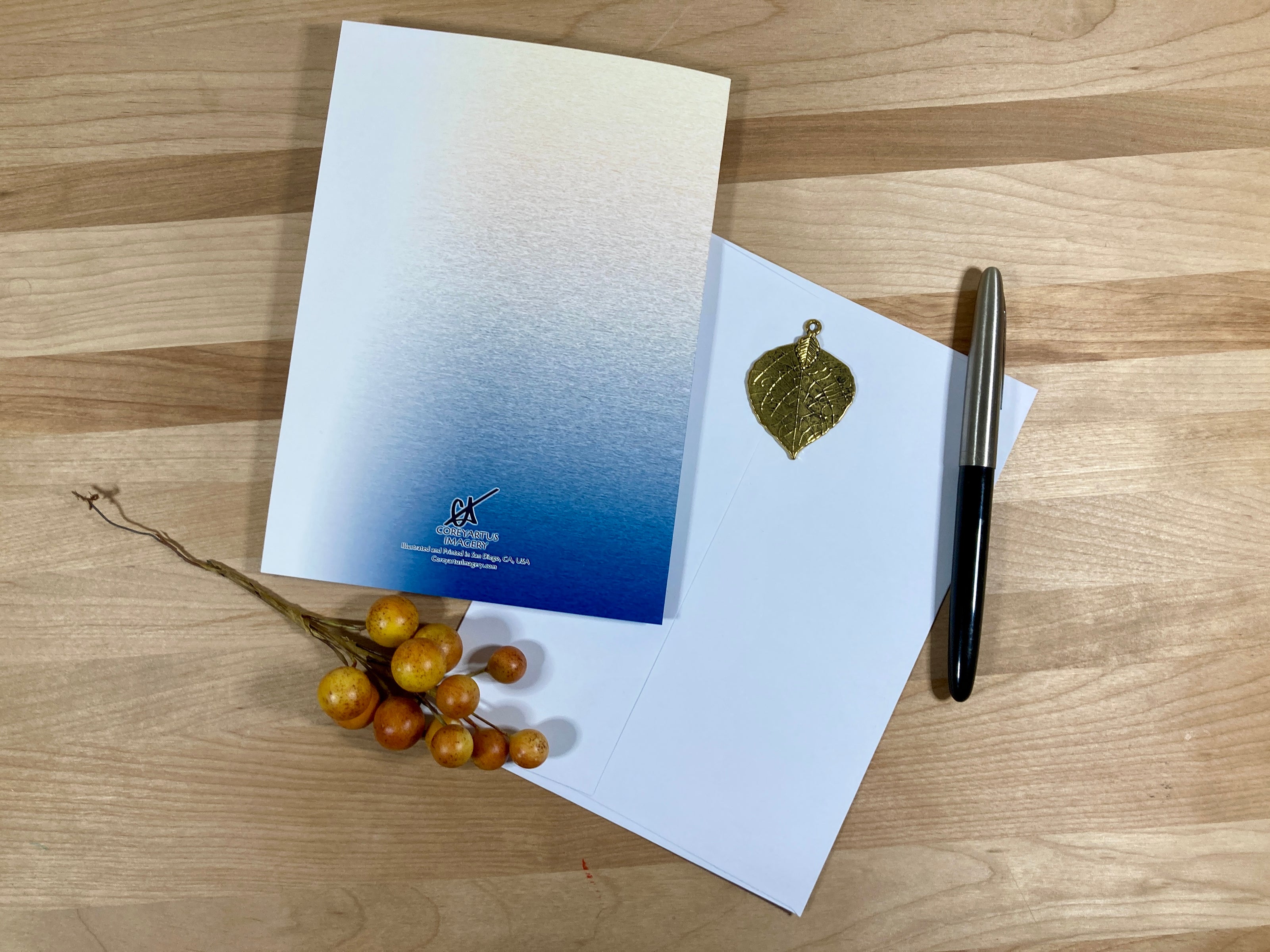 Greeting card with envelope and pen on a wooden surface