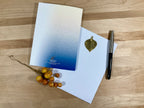 Greeting card with envelope and pen on a wooden surface