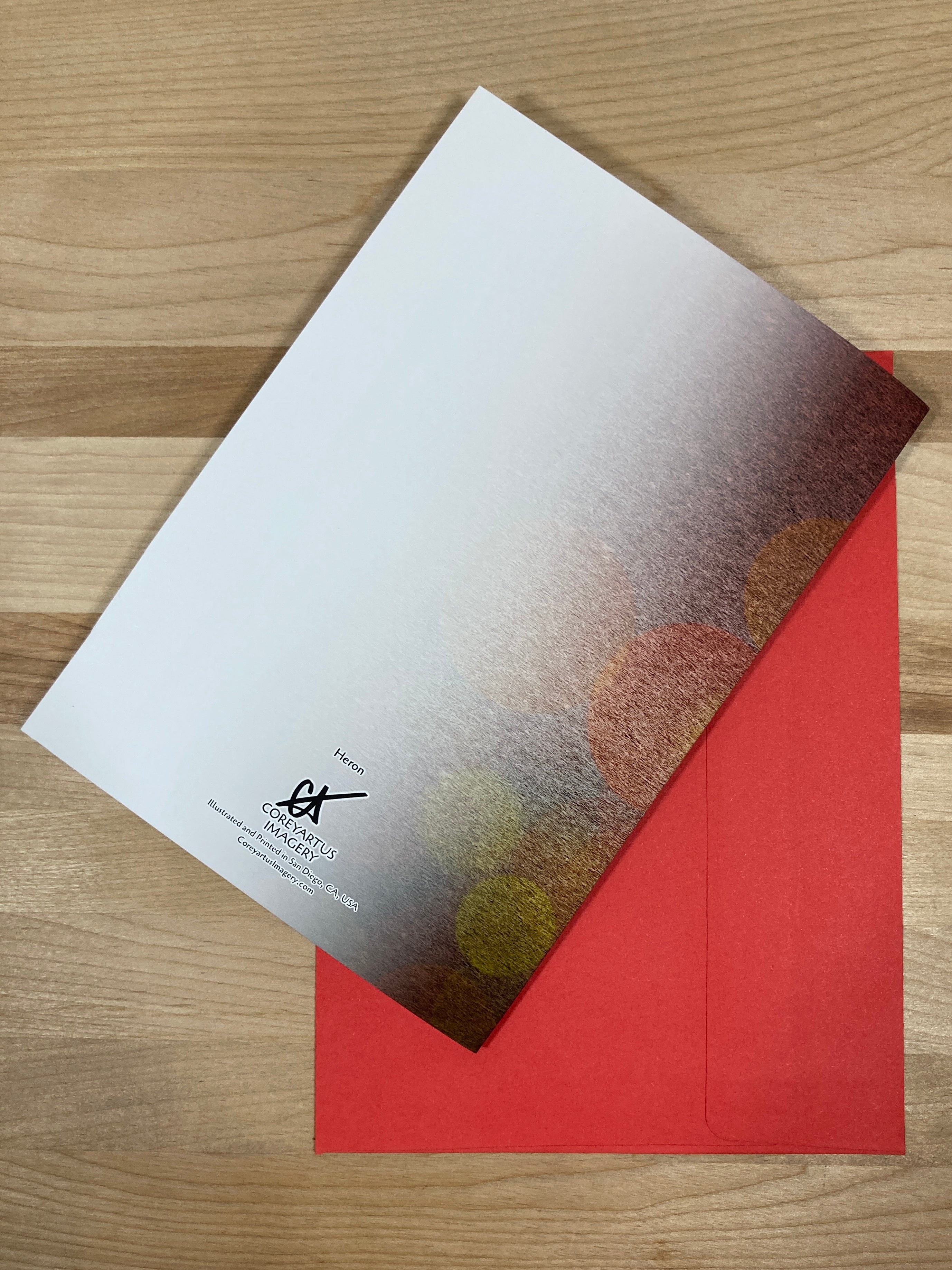 Greeting card with abstract design on a red envelope on a wooden surface