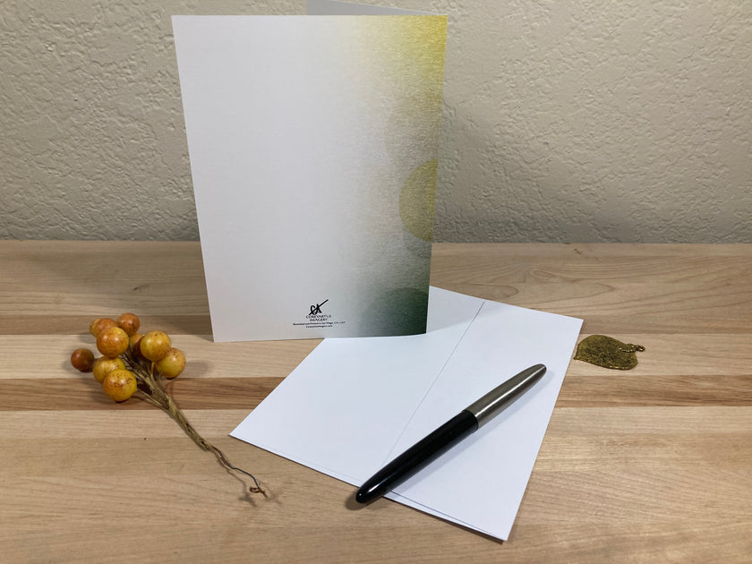 White card with envelope and pen on a wooden surface