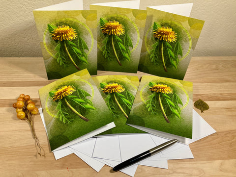 Set of greeting cards with dandelion design on a wooden surface.