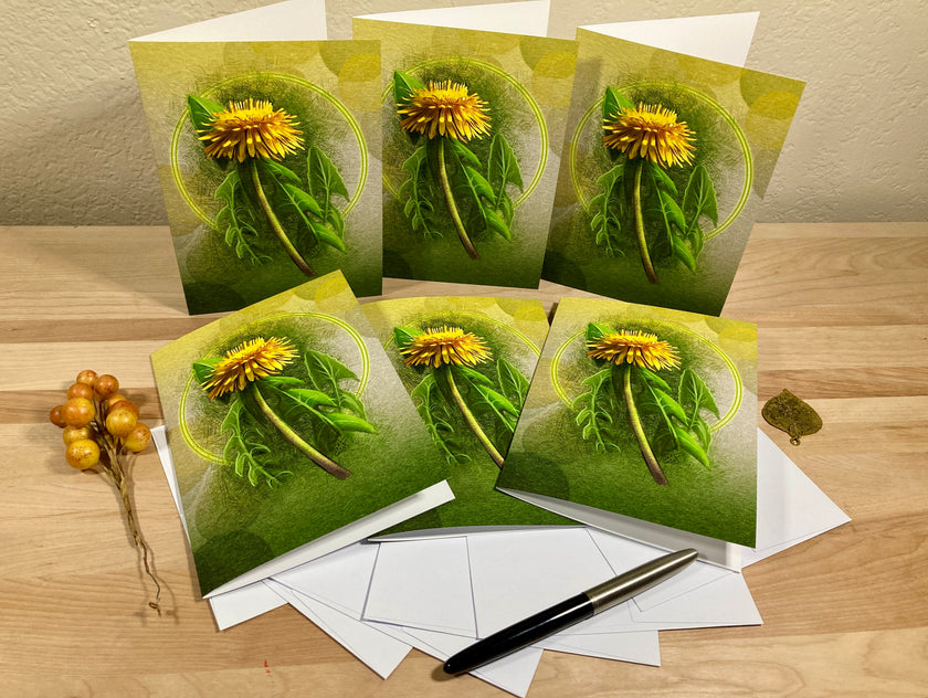 Set of greeting cards with dandelion design on a wooden surface.