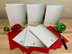 Set of white greeting cards with a pen and decorative balls on a wooden surface