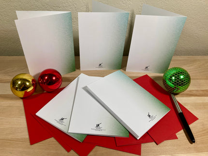 Set of white greeting cards with a pen and decorative balls on a wooden surface