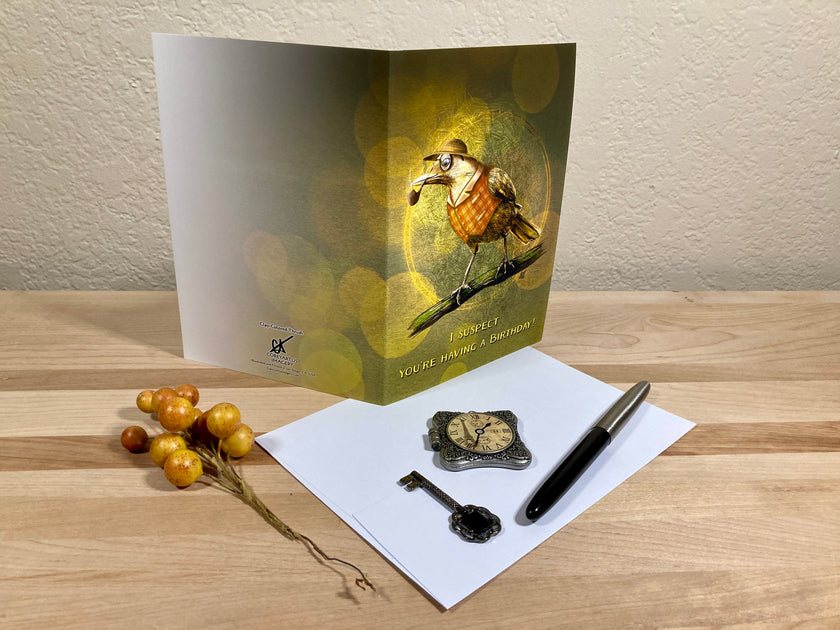 Greeting card with a bird illustration on a wooden surface with stationery items.