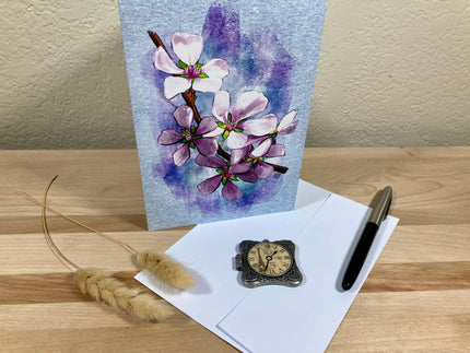 Floral painting, letterhead, pen, and pocket watch on a wooden surface