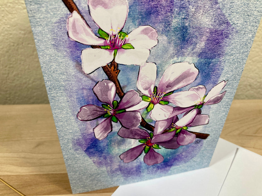 Card with watercolor illustration of pink flowers on a blue background