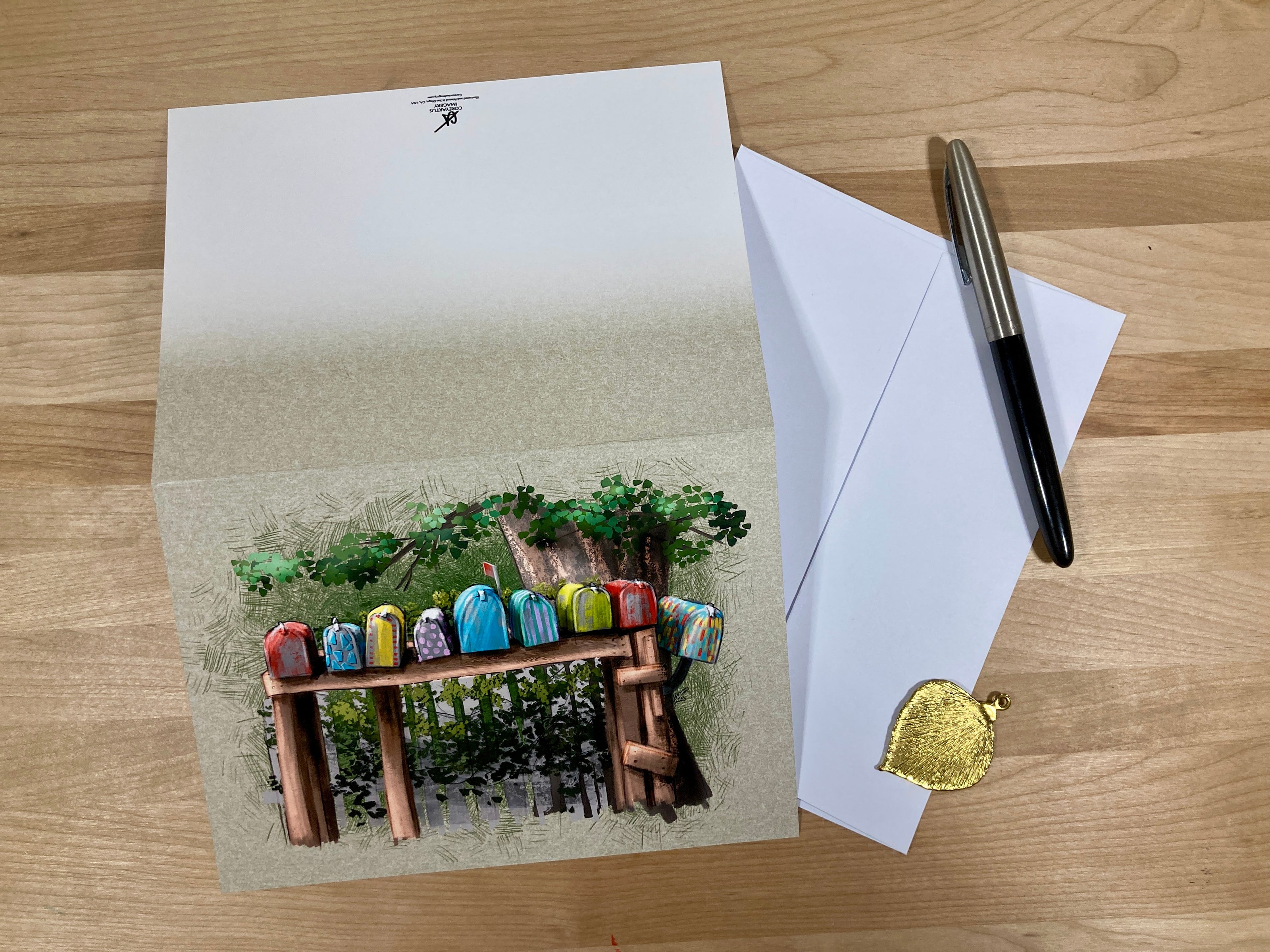 Greeting card with colorful stones on a wooden bench, envelope, and pen on a wooden surface
