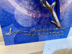 Blue card with silver branch and text on a wooden surface