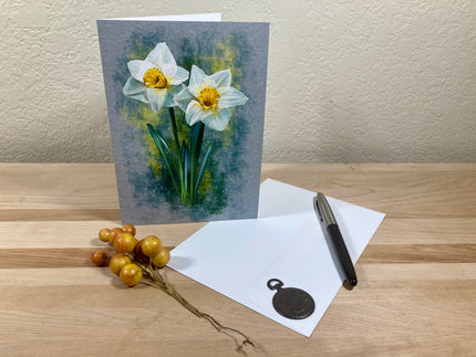 Greeting card with daffodil design on a wooden surface with a pen and decorative elements.